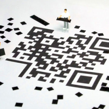 Miniaturfiguren setzen einen QR-Code zusammen