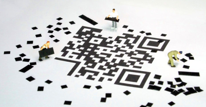 Miniaturfiguren setzen einen QR-Code zusammen